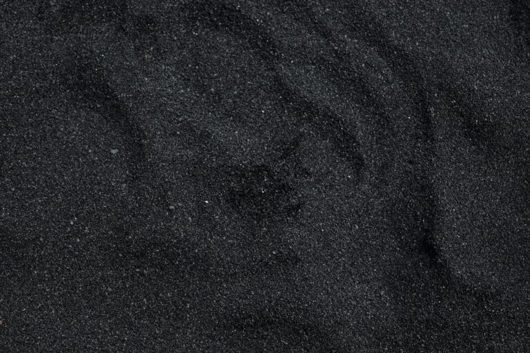 Close-up of black sand texture from Waimea Beach in Hawaii. Ideal for backgrounds.